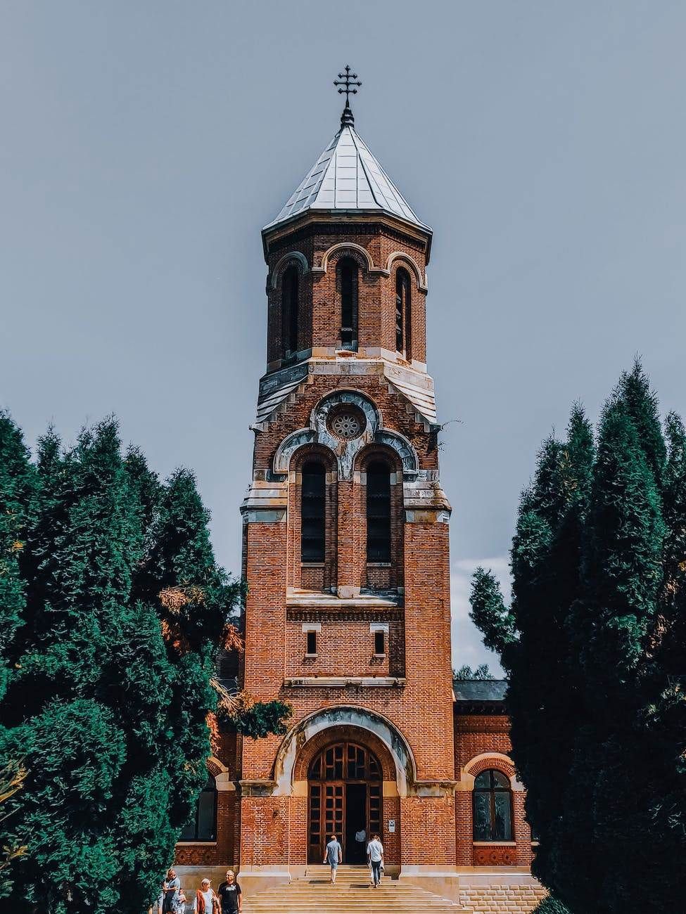 old brick church with arched windows against cloudless sky