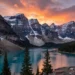 A panoramic view of the Rocky Mountains in Canada at sunset, with snow-capped peaks reflecting in a turquoise lake (Moraine Lake), pine trees in the foreground, vibrant orange and pink sky, photorealistic style, high detail, dramatic lighting.